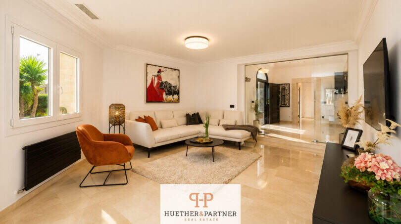 Helles Wohnzimmer der Villa Sa Torre mit Marmorboden, cremefarbenem Sofa und modernem Design.
