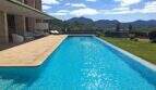 Infinity-Pool der Designer-Finca in Felanitx mit Bergpanorama, Sonnenliegen und moderner Architektur