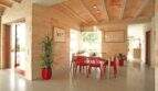 Helles Esszimmer der Designer-Finca mit roten Stühlen, Natursteinwänden und elegantem Gewölbedecke in Felanitx.