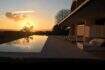Infinity pool of the designer finca Felanitx at sunset with lounge area and panoramic view