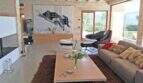 Elegantes Wohnzimmer der Designer-Finca in Felanitx mit Natursteinwänden, modernen Möbeln und großer Kunstinstallation.