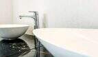 Moderno lavabo doble sobre placa de mármol negro con grifo cromado en el apartamento de lujo en Felanitx