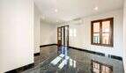 Sala de estar vacía del apartamento de lujo en Felanitx con suelos de mármol negro, aire acondicionado y ventanas de madera