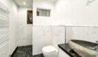 Baño moderno del apartamento de lujo en Felanitx con baldosas de mármol, lavabo de piedra natural e inodoro suspendido