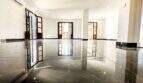 Sala de estar vacía con suelos de mármol negro pulido brillante y tres puertas balconeras de madera en apartamento de lujo en Felanitx
