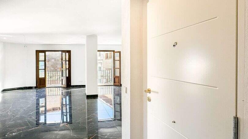Entrada luminosa del apartamento de lujo en Felanitx con suelos de mármol y puertas balconeras francesas