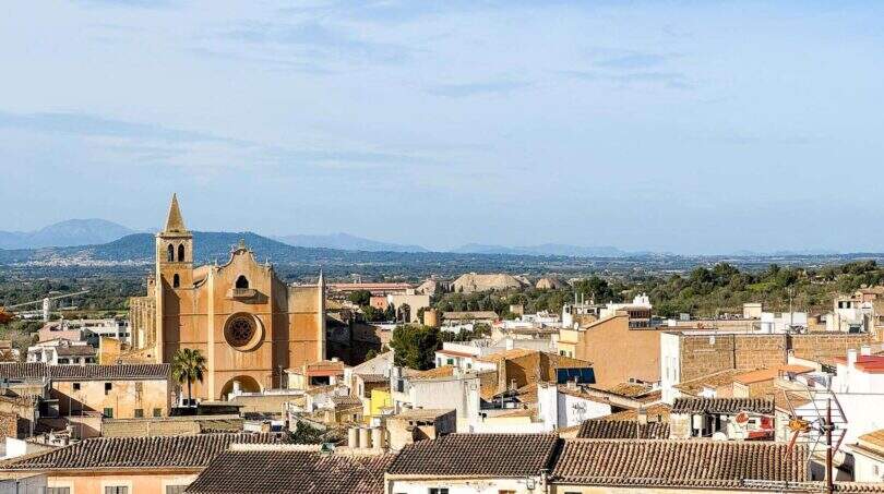Vistas panorámicas sobre los tejados de Felanitx con iglesia histórica, zonas verdes y montañas al fondo