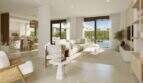 Helles Wohnzimmer mit weißen Sofas, Natursteinfliesen und Glasfront zum privaten Pool im Neubau-Chalet Palma