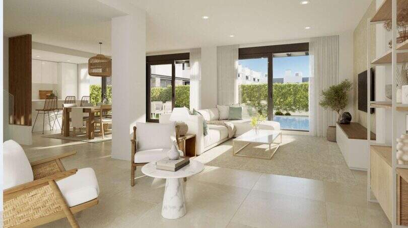 Helles Wohnzimmer mit weißen Sofas, Natursteinfliesen und Glasfront zum privaten Pool im Neubau-Chalet Palma