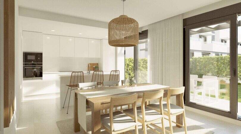 Heller Wohn-Essbereich mit moderner Küche, Holztisch und Terrassenzugang im Neubau-Chalet Palma