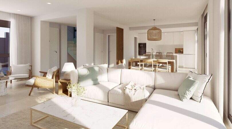Heller Wohnbereich eines Neubau-Chalets in Palma mit weißem Sofa, Marmortresen und offener Küche