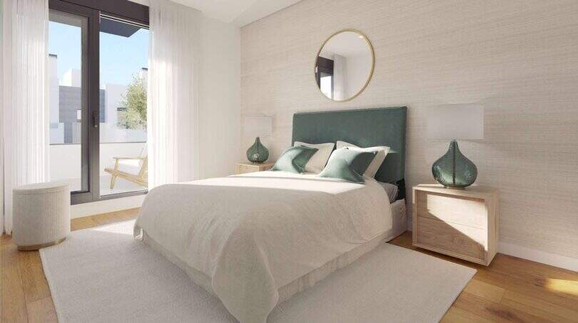 Helles Schlafzimmer im Neubau-Chalet Palma mit grünem Polsterbett, Holzboden und Balkonzugang