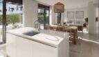 Modernes Neubau-Chalet in Palma: offene Küche mit Insel, Essbereich und Wohnzimmer mit Poolblick