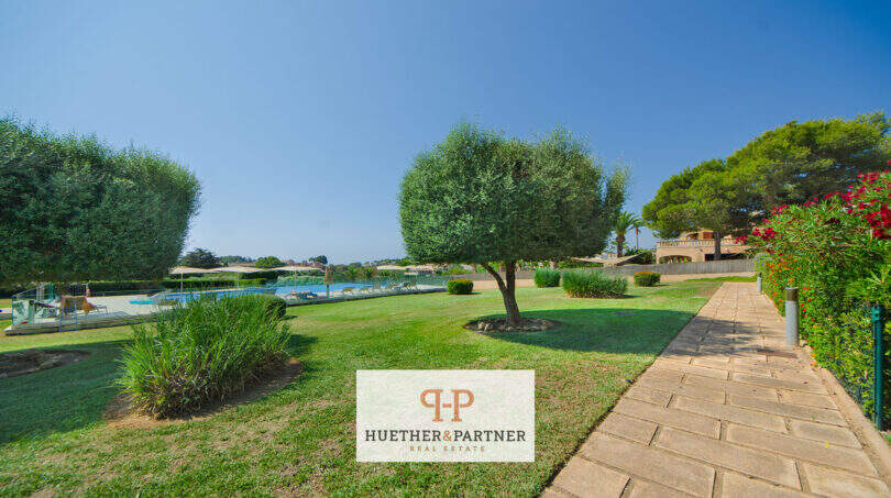 Gepflegter Garten mit Steinweg, Pool und Vegetation beim Reiheneckhaus in Porto Cristo Novo.
