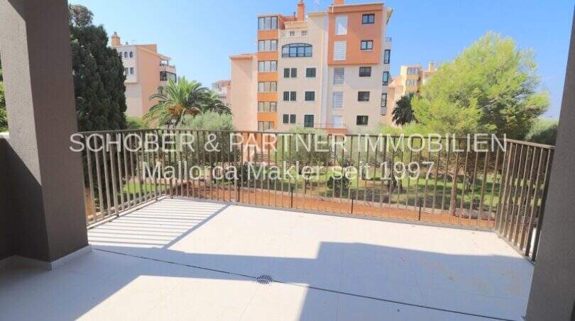 Amplia terraza con barandilla de metal, vistas al jardín y casas multifamiliares en Cala Millor, complejo de apartamentos de nueva construcción