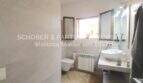 Modern bathroom in Son Servera with wall-mounted toilet, sink, radiator and window.