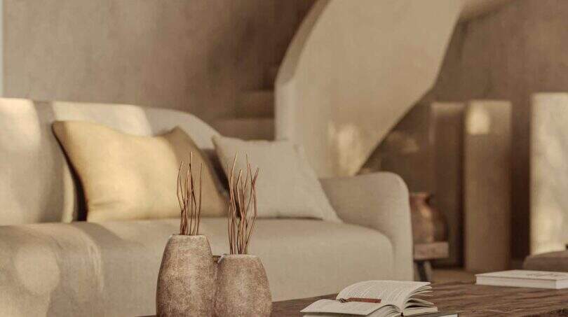 Elegantes Wohnzimmer der Designer-Villa Santanyí mit Wendeltreppe, Holztisch und Naturdekor