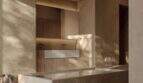 Luxus-Badezimmer der Designer-Villa Santanyí mit freistehendem Steinbad und warmen Erdtönen
