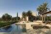 Außenbereich der Designer-Villa Santanyí mit Infinity-Pool, Sonnenliegen, Pergola und mediterranem Garten.