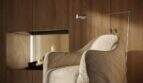 Wohnzimmer der Designer-Villa Santanyí: Sessel, Kamin, Holzwand – modernes Wohnambiente.