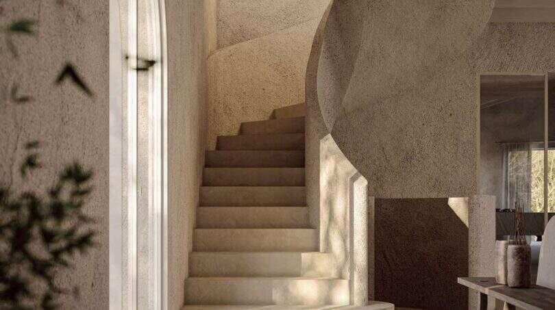 Heller Eingangsbereich der Designer-Villa in Santanyí mit geschwungener Steintreppe und Rundbogenfenster