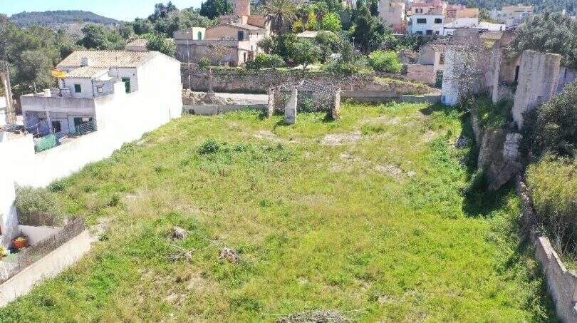 Unbebautes Grundstück in Felanitx mit Grünfläche, Ruinenmauern und Blick auf umliegende Gebäude und Hügel.