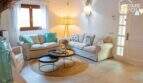 Helles Wohnzimmer mit weißen Sofas, Naturjuteteppich und Strandhaus-Dekor im Bungalow Alcúdia