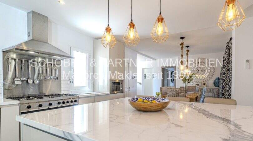 Moderne Designerküche mit Marmorarbeitsplatte, Hängelampen und Profi-Herd in mediterraner Villa Sa Coma.