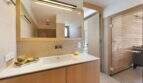 Modern bathroom with wooden vanity, illuminated mirror and sauna in design house S'Alqueria Blanca