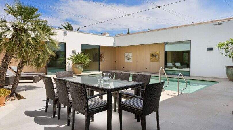 Modern terrace with dining table, chairs and pool at design house in S'Alqueria Blanca