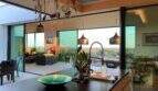 Modern design kitchen with cooking island, hanging utensils and panoramic windows with sea view in S'Alqueria Blanca
