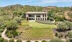 Aerial view modern design house in S'Alqueria Blanca with well-maintained garden, green spaces and hilly landscape