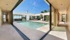 Open living area with panoramic sliding doors to the private pool and courtyard in modern design house