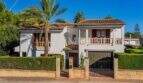 Außenansicht mediterranes Einfamilienhaus Sa Coma: weiße Fassade, Terrakottadach, Palme, Balkon, Garage und gepflegte Hecken.