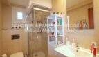 Baño luminoso con ducha de cristal, lavabo y estantería blanca en cuidado apartamento de 4 habitaciones en Porto Cristo