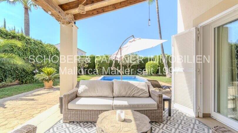 Überdachte Terrasse mit Loungesofa, Sonnenschirm und Pool der mediterranen Villa in Sa Coma.