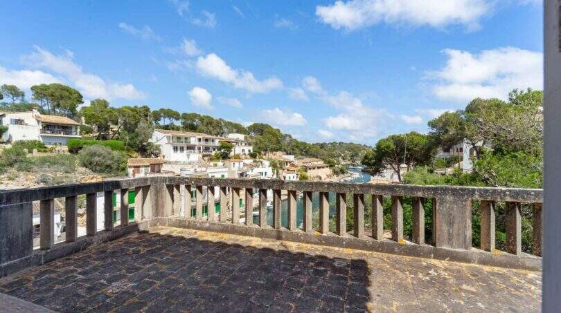 Steintetrasse mit Balustrade und Panoramablick auf den Hafen von Cala Figuera mit weißen Häusern
