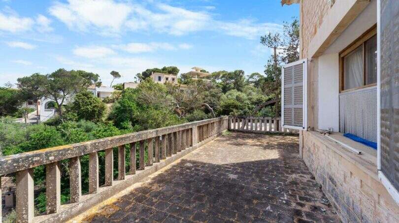 Geräumige Terrasse mit Steinbalustrade, Blick auf bewaldete Hügel und mediterrane Villen in Cala Figuera
