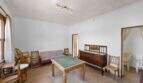 Wohnzimmer der Villa in Cala Figuera mit antikem Holzmöbeln, grünem Spieltisch und Rattanstühlen
