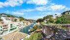 Blick vom Balkon auf den malerischen Hafen von Cala Figuera mit Booten und weißen Häusern