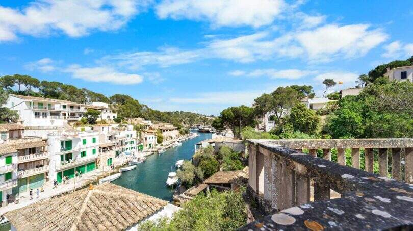 Blick vom Balkon auf den malerischen Hafen von Cala Figuera mit Booten und weißen Häusern