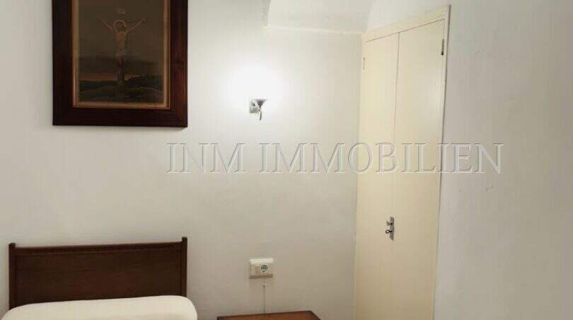 Schlafzimmer mit Gewölbedecke, Einzelbett, Holzmöbeln und Kreuzigungsbild in Dorfhaus Felanitx