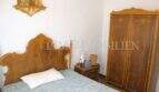 Schlafzimmer mit antikem Holzbett, passendem Kleiderschrank und religiösem Wandschmuck im Dorfhaus Felanitx