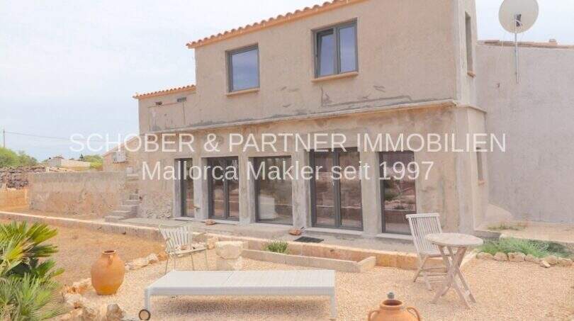 Außenansicht Landhaus Mallorca: Rustikale Finca mit Terrasse, Amphoren und Gravel-Garten in Portocristo