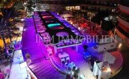 Beleuchtete Bar-Terrasse an der Playa de Palma bei Nacht mit farbigen LED-Lichtern in erster Meereslinie.