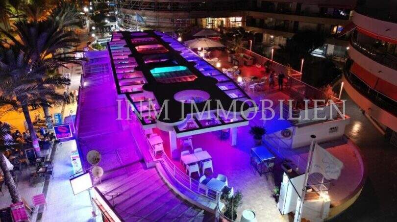Beleuchtete Bar-Terrasse an der Playa de Palma bei Nacht mit farbigen LED-Lichtern in erster Meereslinie.