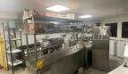 Gewerbliche Profiküche mit Edelstahlausstattung, Kochstation, Regalen und Kühlgeräten in Bar/Cafeteria Palma de Mallorca