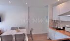 Helle Wohnküche mit weißen Einbauschränken, Esstisch für 4 Personen und modernem Holzboden im Apartment Palmanova