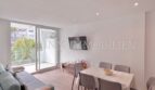 Helles Wohnzimmer mit Esstisch, Sofa, TV und Balkon mit Palmenblick in Palmanova-Apartment
