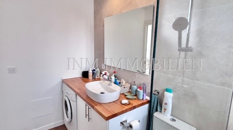Modernes Badezimmer mit Waschtisch, Spiegel, Dusche und Waschmaschine im Apartment Palmanova